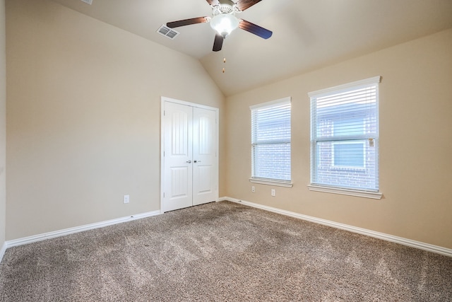 unfurnished bedroom featuring baseboards, a ceiling fan, vaulted ceiling, carpet floors, and a closet