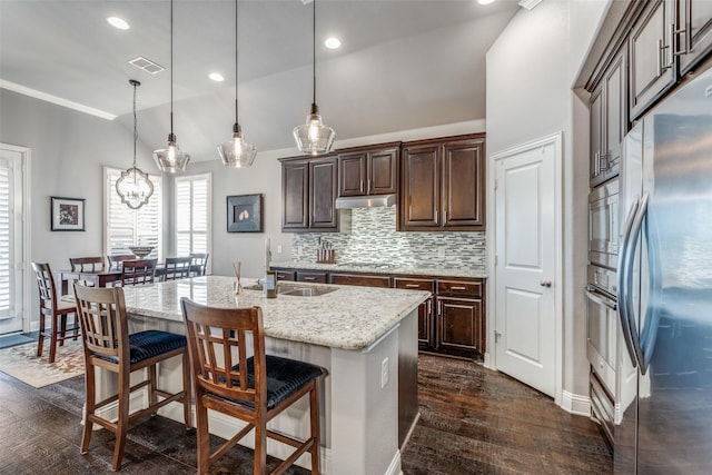 kitchen with visible vents, appliances with stainless steel finishes, dark wood-type flooring, under cabinet range hood, and a sink