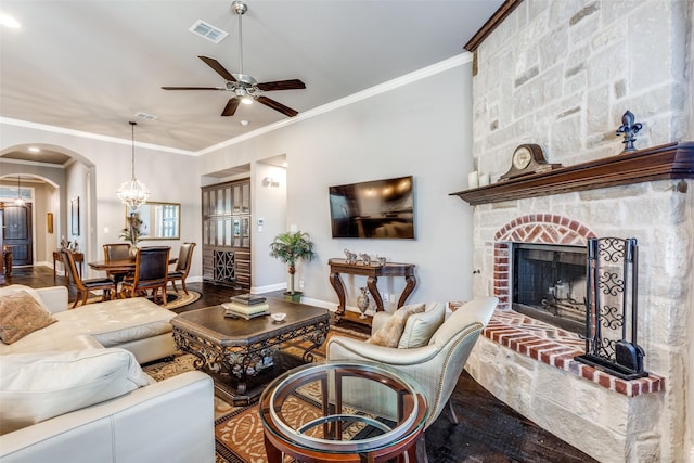 living room with baseboards, visible vents, arched walkways, wood finished floors, and a fireplace