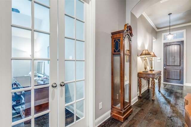 entrance foyer featuring arched walkways, french doors, crown molding, dark wood-type flooring, and baseboards