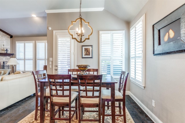 dining area with a chandelier, lofted ceiling, baseboards, and wood finished floors