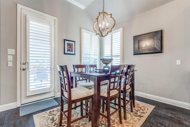 dining room with baseboards, a chandelier, vaulted ceiling, and wood finished floors