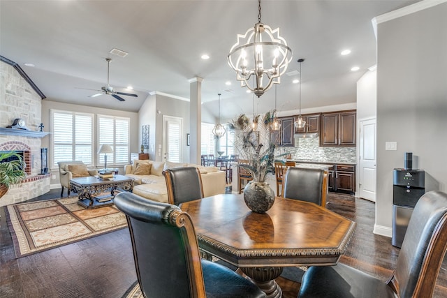 dining space featuring ornamental molding, dark wood finished floors, a large fireplace, and plenty of natural light