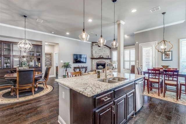 kitchen with visible vents, dark wood-style floors, a sink, a fireplace, and stainless steel dishwasher