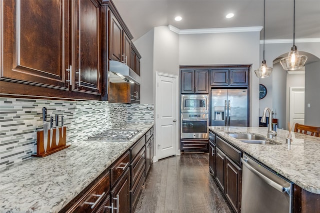 kitchen featuring dark brown cabinetry, light stone countertops, stainless steel appliances, under cabinet range hood, and a sink