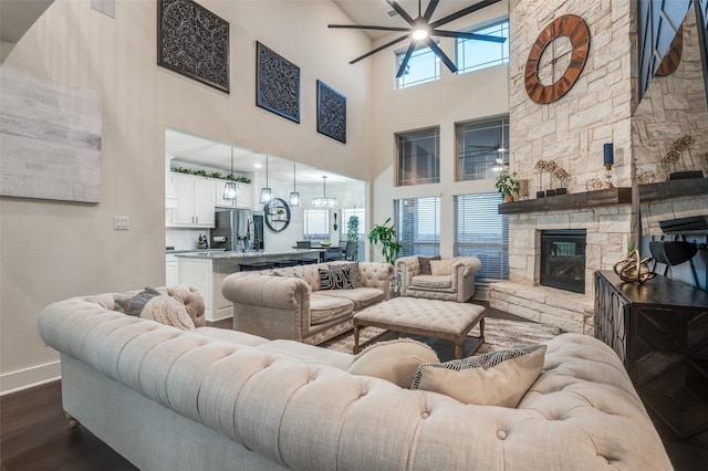 living room featuring dark wood-type flooring, a fireplace, and baseboards