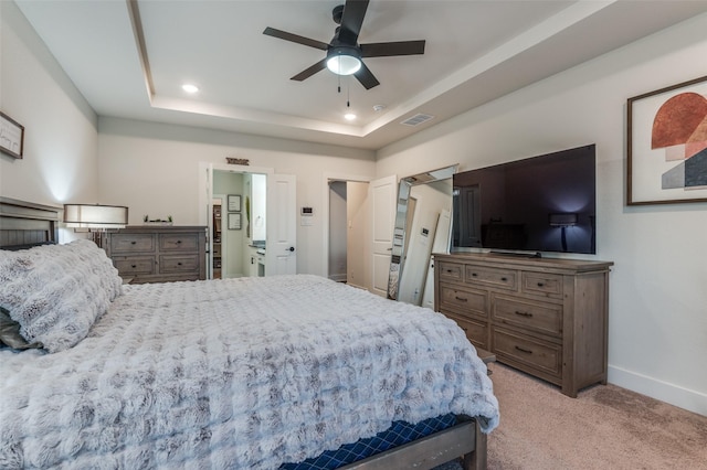 bedroom with recessed lighting, light carpet, visible vents, baseboards, and a tray ceiling