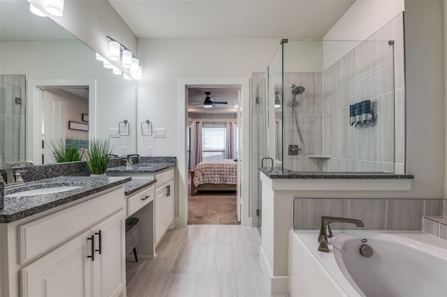 ensuite bathroom with double vanity, tiled shower, a sink, and connected bathroom