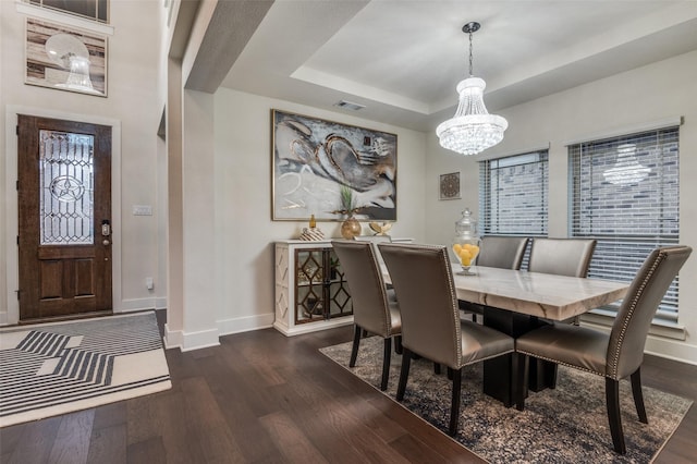 dining area with a raised ceiling, baseboards, visible vents, and dark wood-style flooring