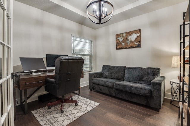 office featuring an inviting chandelier, a raised ceiling, baseboards, and wood finished floors