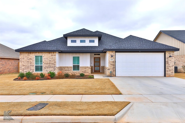 prairie-style home featuring brick siding, a shingled roof, an attached garage, board and batten siding, and driveway