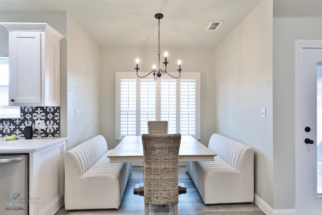 dining room featuring light wood-style floors, visible vents, baseboards, and an inviting chandelier