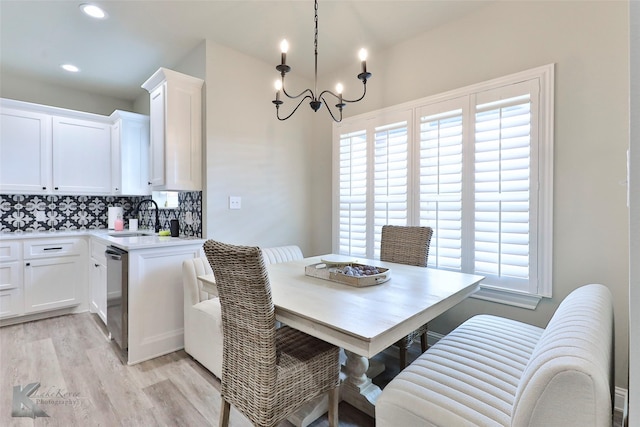 dining room with light wood finished floors, recessed lighting, and an inviting chandelier