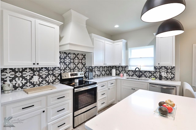 kitchen featuring custom exhaust hood, light countertops, decorative backsplash, appliances with stainless steel finishes, and a sink