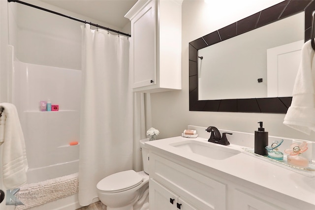 bathroom with shower / tub combo, vanity, and toilet