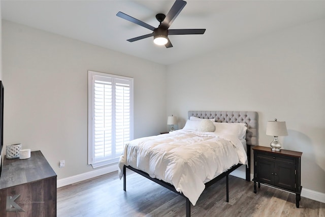 bedroom with ceiling fan, baseboards, and wood finished floors