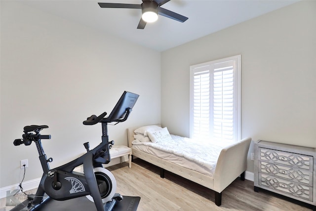 bedroom with ceiling fan, wood finished floors, and baseboards