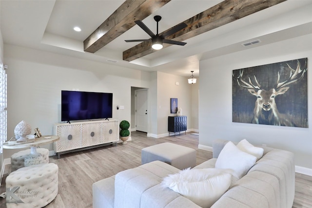 living room with visible vents, a ceiling fan, wood finished floors, beamed ceiling, and baseboards