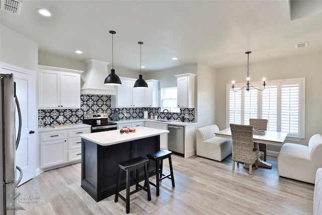 kitchen with tasteful backsplash, visible vents, custom range hood, stainless steel appliances, and a sink