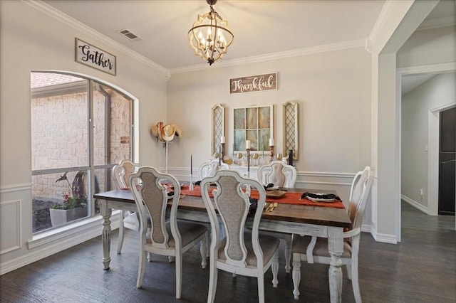 dining room with a chandelier, visible vents, ornamental molding, and wood finished floors