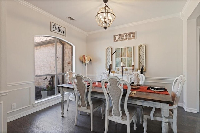 dining area with visible vents, a chandelier, dark wood finished floors, and ornamental molding