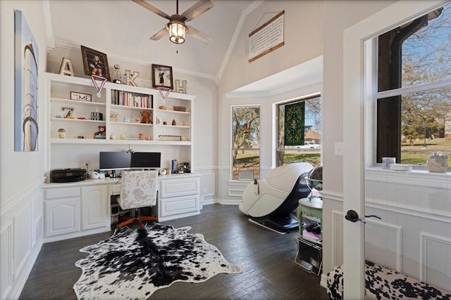 office featuring built in study area, lofted ceiling, dark wood-type flooring, wainscoting, and crown molding