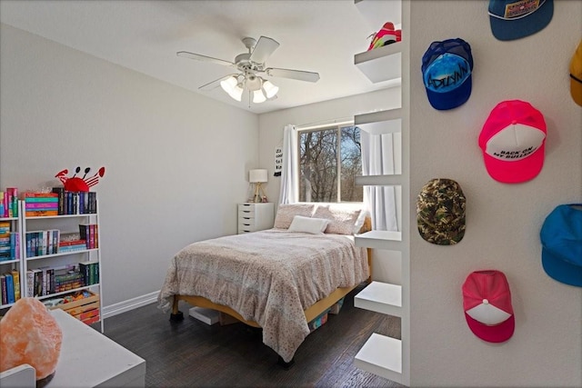 bedroom featuring ceiling fan, baseboards, and wood finished floors