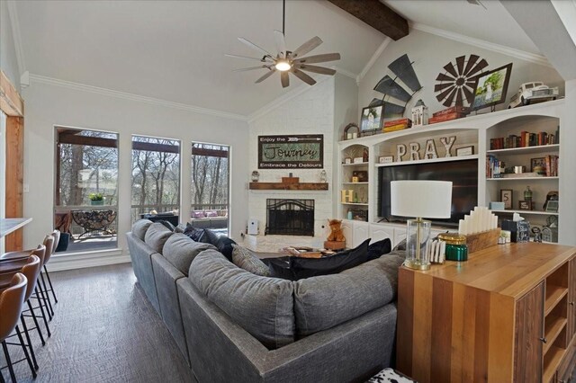 living room featuring wood finished floors, ceiling fan, crown molding, beamed ceiling, and a large fireplace