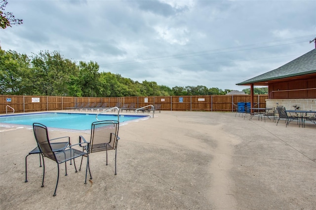 pool with a patio and a fenced backyard