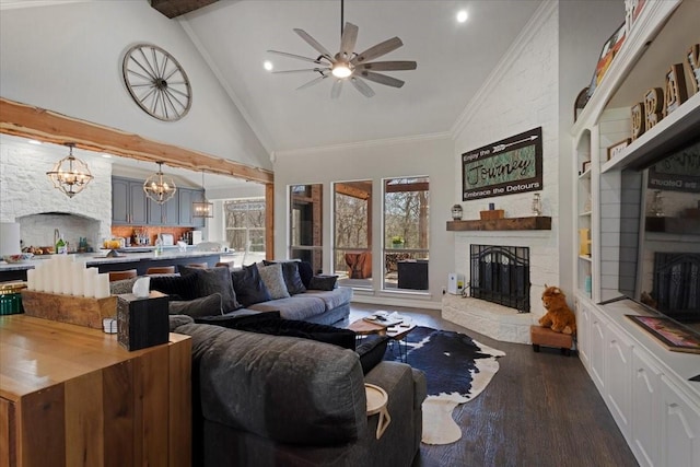 living area with dark wood-style floors, high vaulted ceiling, a stone fireplace, beamed ceiling, and ceiling fan with notable chandelier