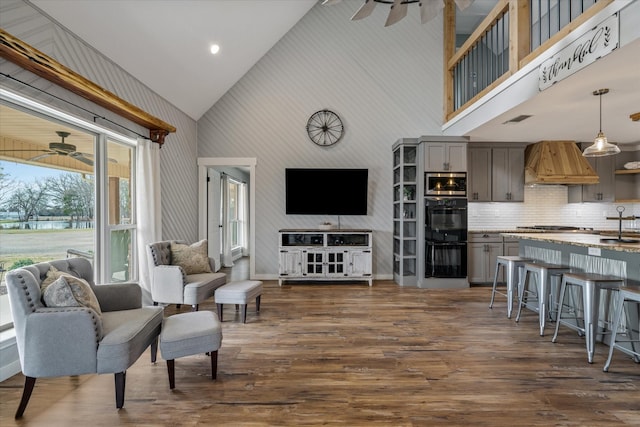 living room featuring ceiling fan, high vaulted ceiling, dark wood-style flooring, and visible vents