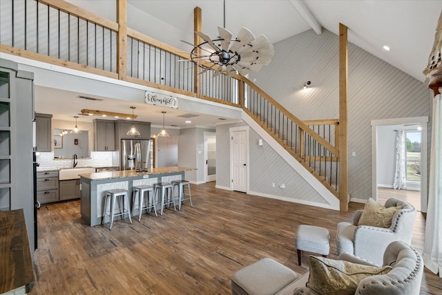 living area featuring stairs, beamed ceiling, dark wood finished floors, and visible vents