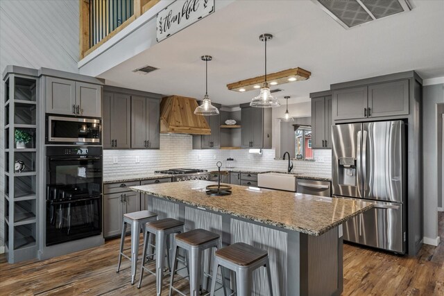 kitchen with gray cabinetry, a sink, visible vents, appliances with stainless steel finishes, and custom exhaust hood