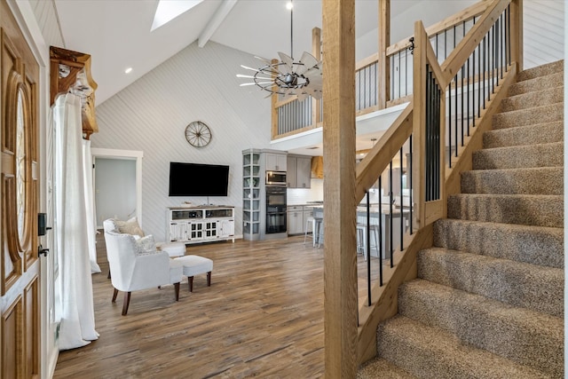 interior space featuring a skylight, dark wood-style floors, an inviting chandelier, high vaulted ceiling, and beam ceiling