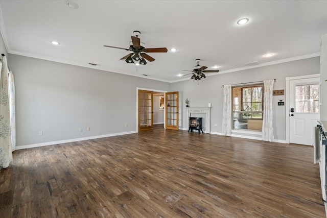 unfurnished living room featuring a lit fireplace, crown molding, baseboards, and wood finished floors