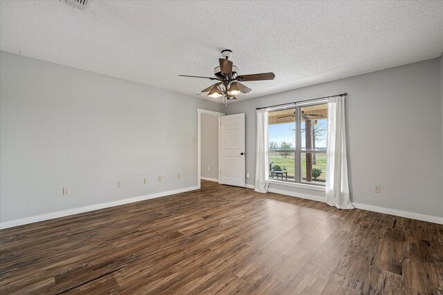 spare room featuring a ceiling fan, dark wood-style flooring, a textured ceiling, and baseboards