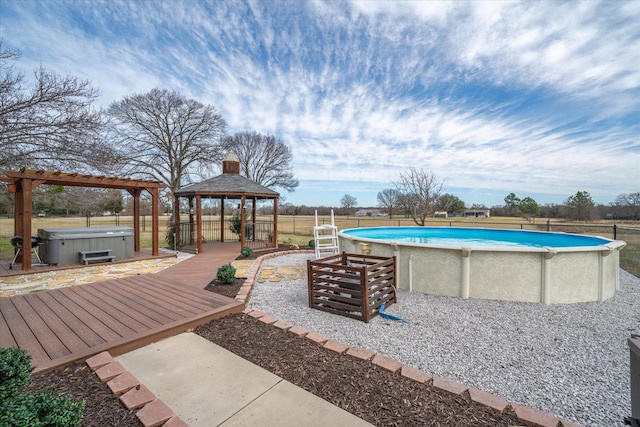 pool featuring a deck, fence, a hot tub, and a gazebo