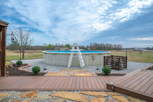 outdoor pool featuring fence and a deck