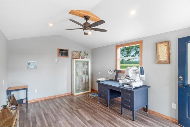 home office featuring lofted ceiling, a wall mounted AC, ceiling fan, wood finished floors, and baseboards