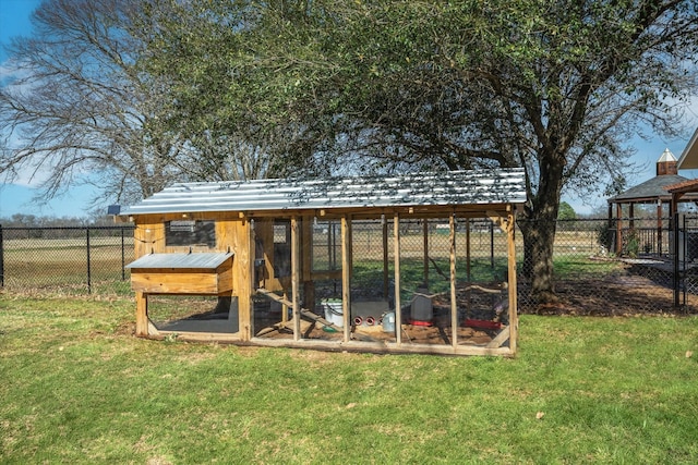 view of poultry coop featuring fence and a yard