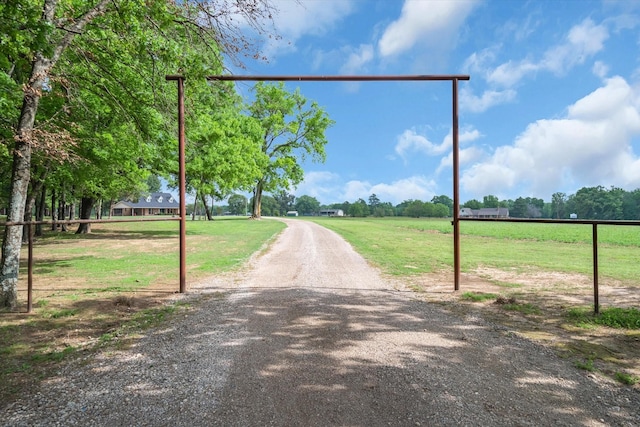 view of road featuring a rural view and gravel driveway