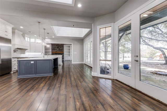 kitchen featuring stainless steel appliances, white cabinetry, light countertops, custom exhaust hood, and dark wood-style floors