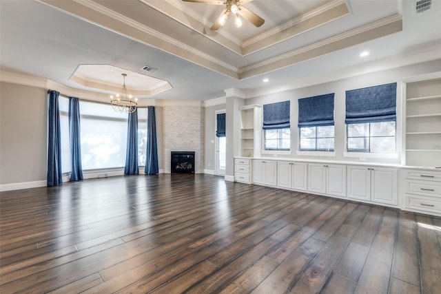 unfurnished living room with visible vents, a raised ceiling, dark wood finished floors, and a stone fireplace