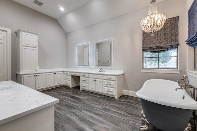 bathroom featuring vaulted ceiling, visible vents, a sink, and wood finished floors