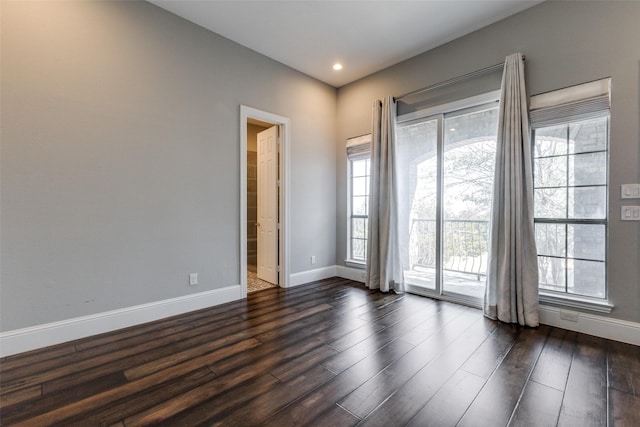 empty room featuring baseboards, dark wood-type flooring, and recessed lighting