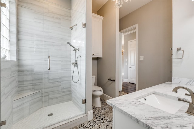 full bathroom with baseboards, a shower stall, toilet, and vanity