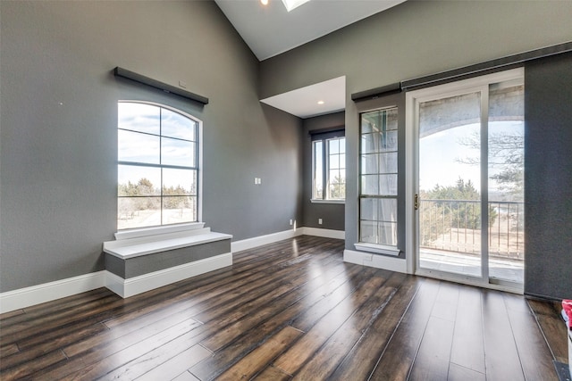 interior space with high vaulted ceiling, baseboards, and wood finished floors