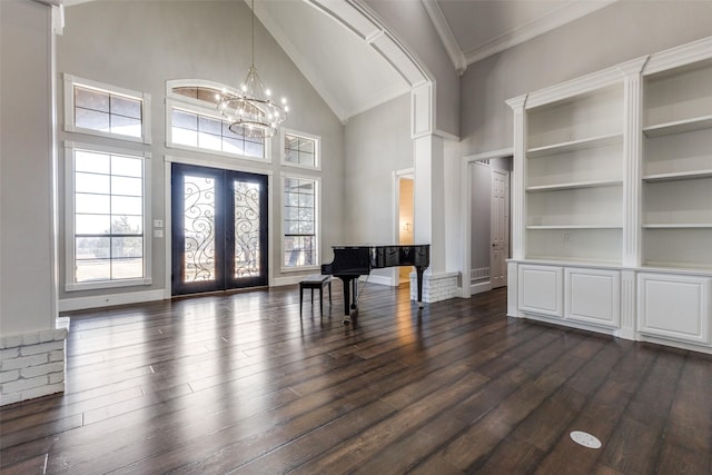 entrance foyer featuring french doors, dark wood-style flooring, high vaulted ceiling, a chandelier, and baseboards