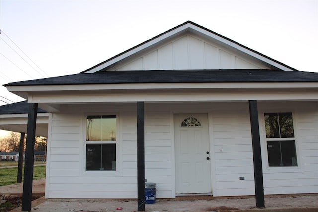 view of front of house featuring a shingled roof, a porch, and board and batten siding