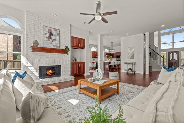 living area featuring recessed lighting, wood finished floors, a ceiling fan, baseboards, and a brick fireplace